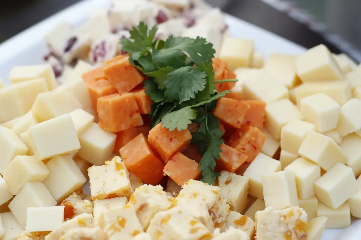A close-up of a delicious assorted cheese platter garnished with fresh herbs.