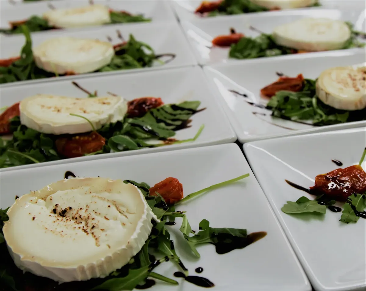 Plates of goat cheese with arugula and balsamic reduction, perfect for appetizers or a light meal.